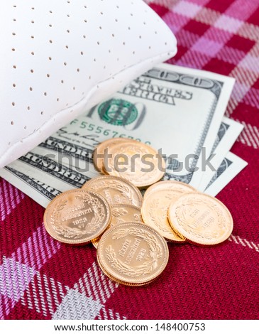 Money and gold tucked away under a pillow during financial crisis