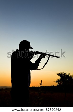 Silhouette of the hunter on a background of a morning dawn