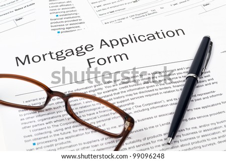 Pen, Glasses and Mortgage Application Form on desktop in business office.