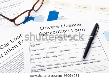 Pen, Glasses and Drivers License Application Form on desktop in business office.