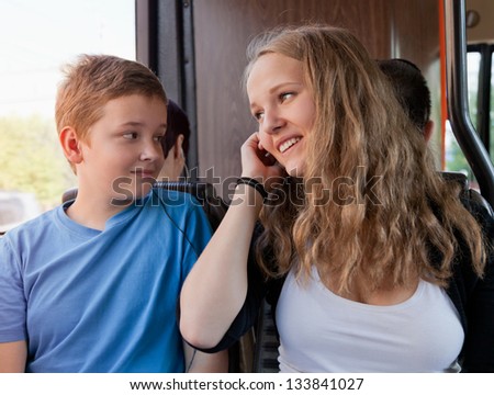 The girl and the boy go in the bus and listen to music in phone
