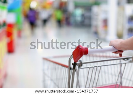 Female hand and shopping trolleys