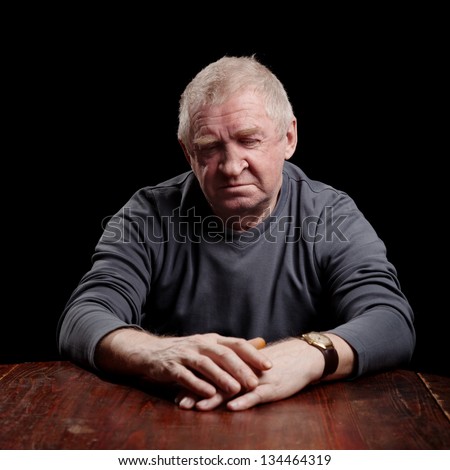 Portrait of a senior man looking very serious, sad or depressed ,studio shot over black.