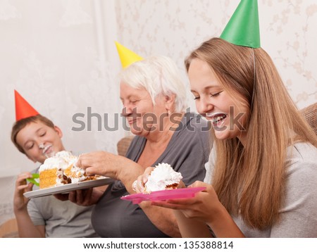 boy and teenage girl on birthday eat a cake
