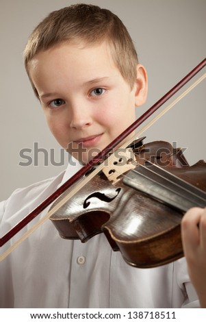 Teenager playing the violin, gray background