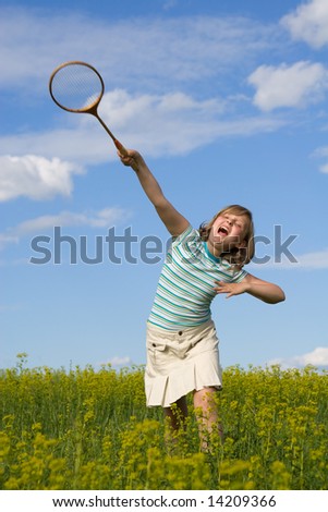 The girl on a meadow play badminton