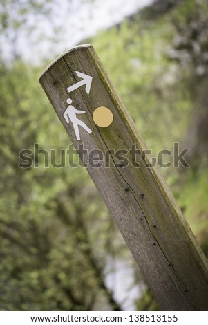 Wooden sign post showing routes and directions