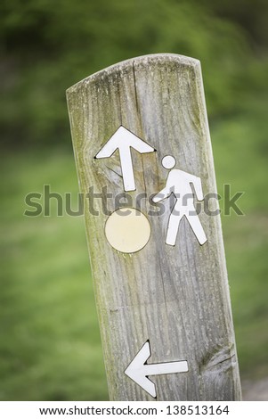 Wooden sign post showing routes and directions