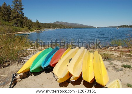 Kayaks and canoes on lake shore; Big Bear Lake, California