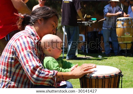 SAN DIEGO, CA - APRIL 19: Visitors playing percussion instruments in a drum circle at Earth Fair on April 19, 2009. The fair is a large annual event held at Balboa Park in San Diego.