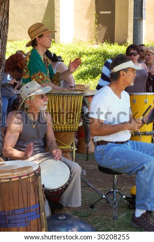 SAN DIEGO, CA - APRIL 19: Musicians play various percussion instruments in a drum circle at Earth Fair on April 19, 2009 in San Diego. The fair is a large annual event held at Balboa Park.