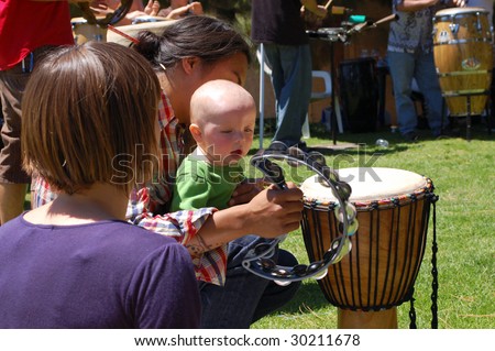 SAN DIEGO, CA - APRIL 19: Visitors play percussion instruments in a drum circle at Earth Fair on April 19, 2009 in San Diego. The fair is a large annual event held at Balboa Park.