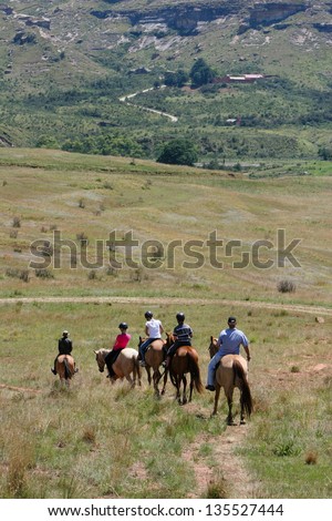 people riding horses in the mountains