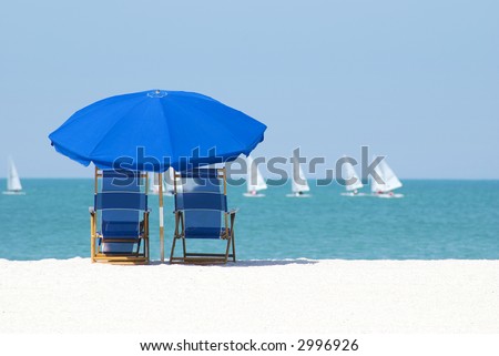 Beach chairs and umbrella to enjoy the passing sailboats on lazy days
