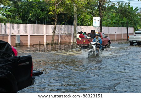 BANGKOK - NOVEMBER 7: Car and Motorcycle navigating through the flood after the heaviest monsoon rain in 20 years in the capital  on November 7, 2011  Nuan Chan Road, bangkok, Thailand.