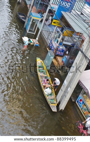 BANGKOK, THAILAND-NOVEMBER 8: People use boats and rafts as transportation through water during the worst flooding in decades on November 8, 2011 Ngam Wong Wan Road, Bangkok, Thailand.