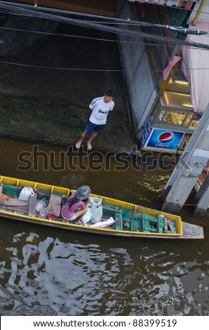 BANGKOK, THAILAND-NOVEMBER 8: People use boats and rafts as transportation through water during the worst flooding in decades on November 8, 2011 Ngam Wong Wan Road, Bangkok, Thailand.