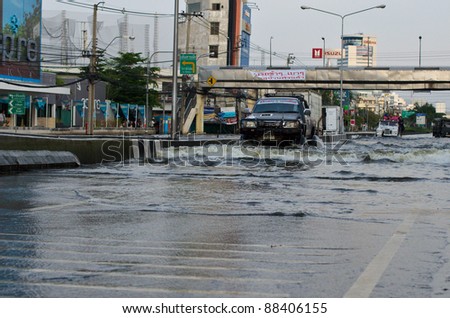 BANGKOK, THAILAND-NOVEMBER 8: Cars and trucks navigate through the flood after the heaviest monsoon rain in 20 years in the capital on  November 8, 2011   Ngam Wong Wan Road, Bangkok, Thailand.