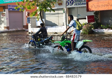 BANGKOK, THAILAND-NOVEMBER 9: Motorcycle navigating through the flood after the heaviest monsoon rain in 20 years in the capital  on November 9, 2011  Nuan Chan Road, bangkok, Thailand.