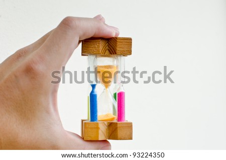colorful sand hourglass timer in male hand on white background