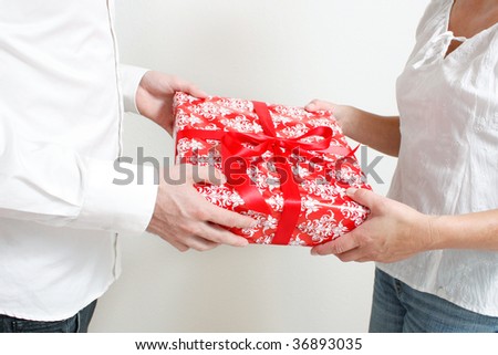 A man giving a christmas present to a woman