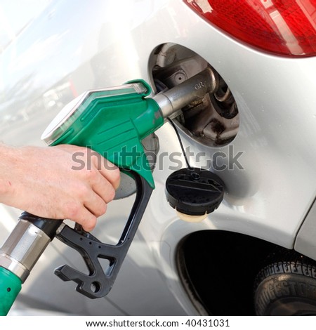 A man pumping gas in to the tank