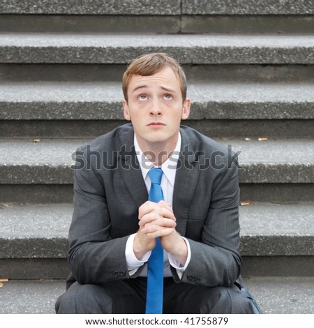 A worried business man sitting on some stairs