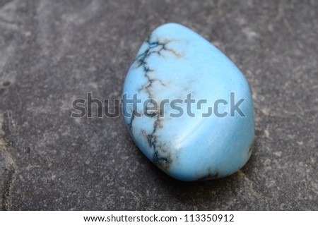 Close up of a blue and black turquoise stone on mineral background
