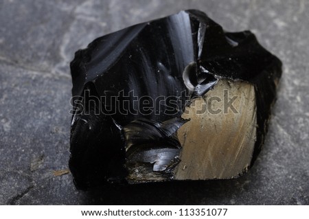 Close up of a black obsidian stone on mineral background