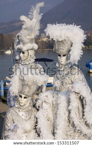 Annecy, France - February 18, 2009: Tree white venetian mask in front of Annecy\'s lake at venetian carnival.