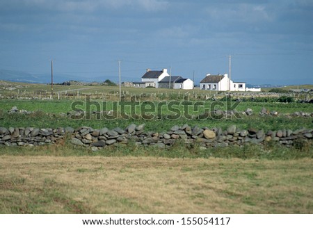 Small white houses in Ireland countryside and view of green fields, Europe