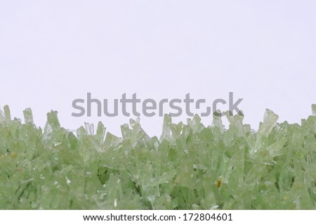 Close up and macro of green crystals on light background