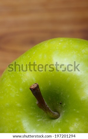 Macro of an appetizing  green granny smith apple over wooden background