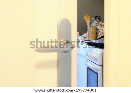 View throught slightly open door upen mess in domestic kitchen