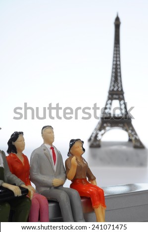 Scene of french people miniature figures in front of Paris Eiffel tower