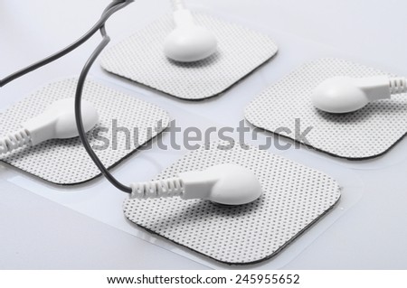 Close up of white electrodes and electrical stimulation device