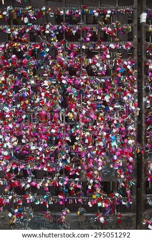 Lot of colored lovers padlocks with first name along a wall