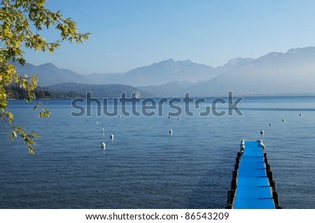 Pontoon with blue carpet and Lake Annecy and its mountain, France