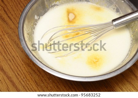 Spots of Vanilla sugar in batter or custard and whisk ready to mix it