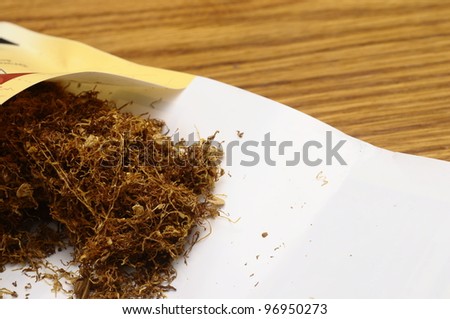 Rolling tobacco in its package on wooden table