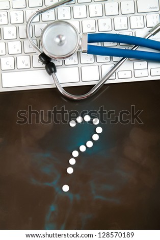 Medicine question mark from tablets, pills, on doctors workplace. Question for doctor