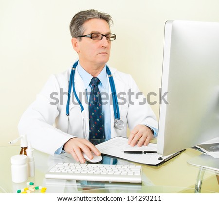 doctor hands on keyboard while using the computer at hospital workplace. Serious doctor's face