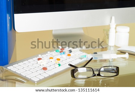 Doctor workplace. Pills, tablets, pen on patient history database and keyboard
