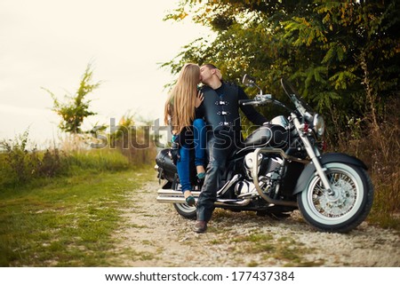 Young couple kiss in mirror on beautiful bike on road.