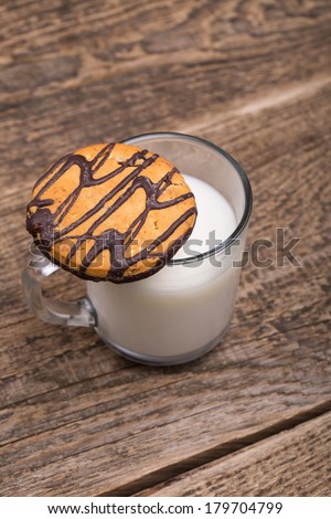 Homemade chocolate and nut cookies with chocolate with a glass of milk on wooden table