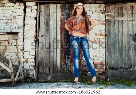 Sexy gorgeous young woman with long hair near old wall