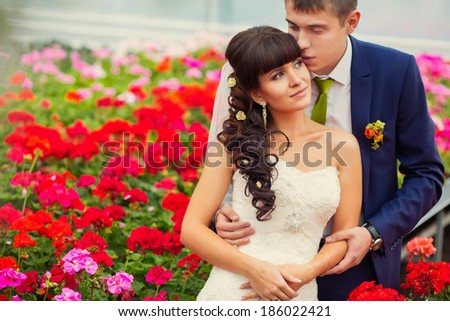 A young couple in love bride and groom, wedding day in summer. Enjoy a moment of happiness and love in a red flowers field