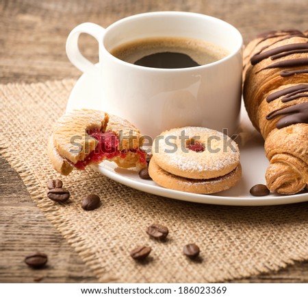 Cappuccino and croissant on wooden table