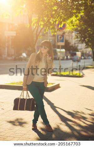 portrait of brunette woman in sunglasses in city at summer sunrise