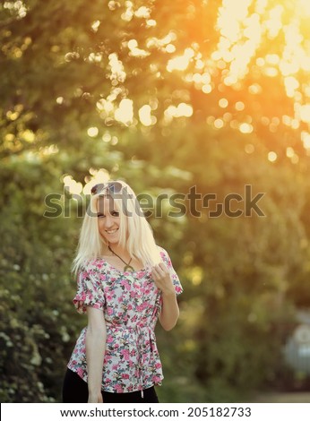 Spring woman in summer dress walking in green park enjoying the sun